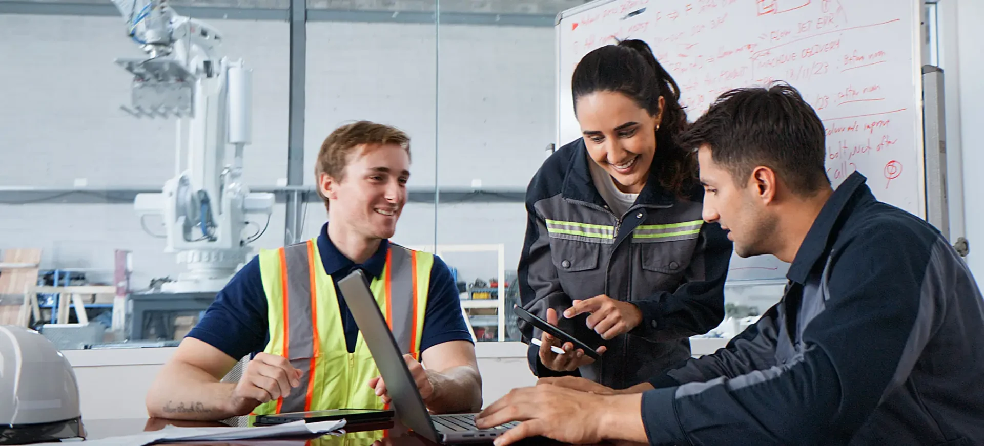 Workers collaborating around a laptop in office.