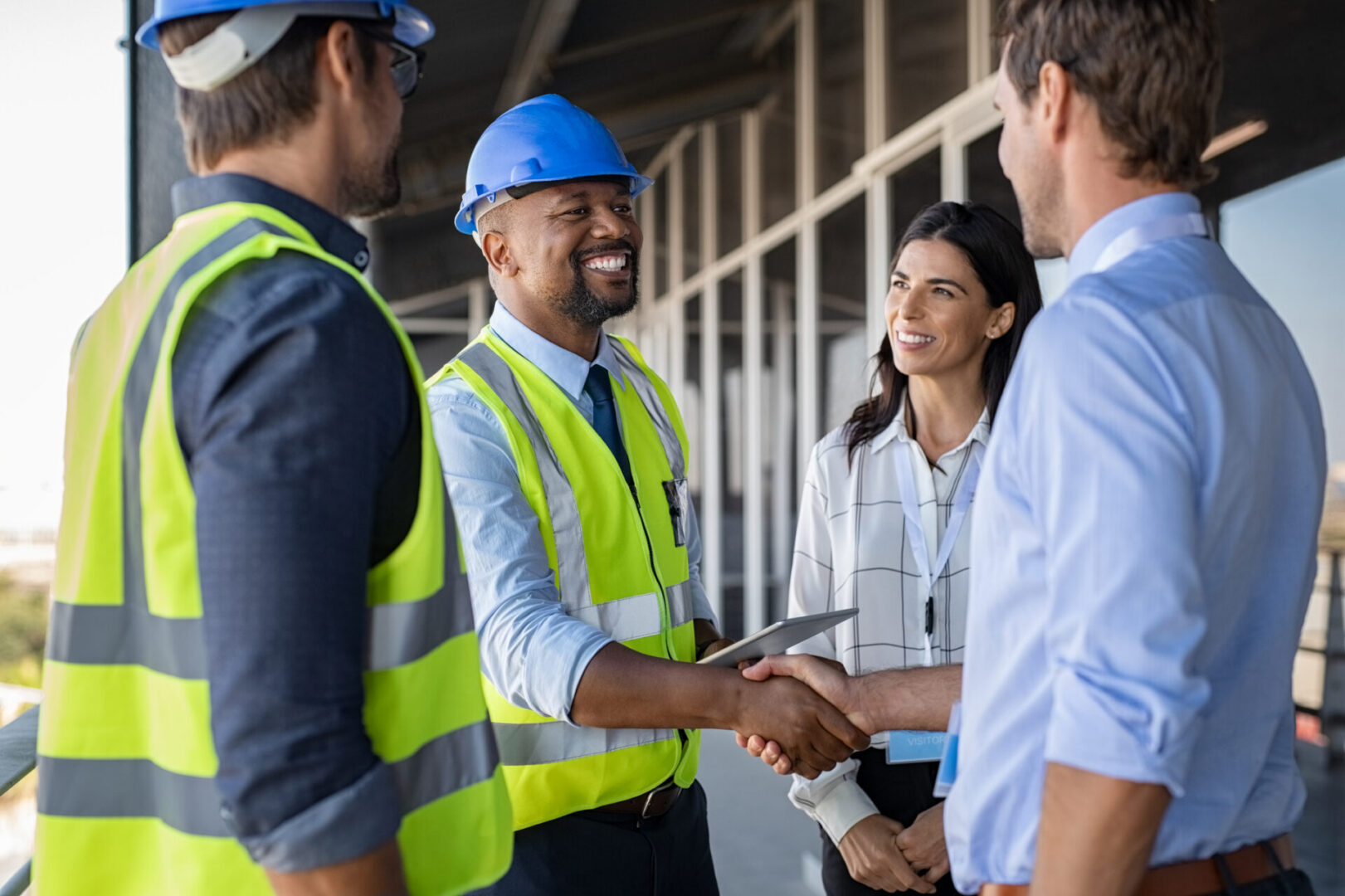 Construction workers and professionals shaking hands.