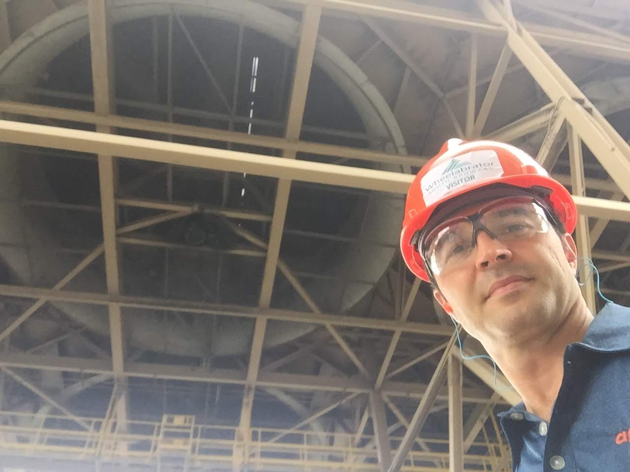 Man wearing hard hat in industrial setting.