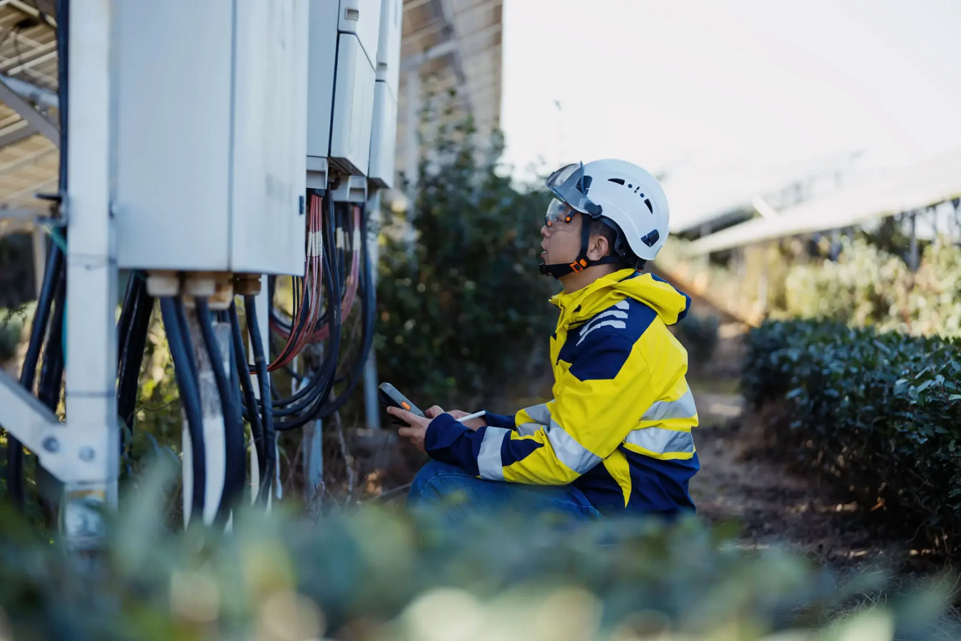 Engineer inspecting solar panel electrical connections.