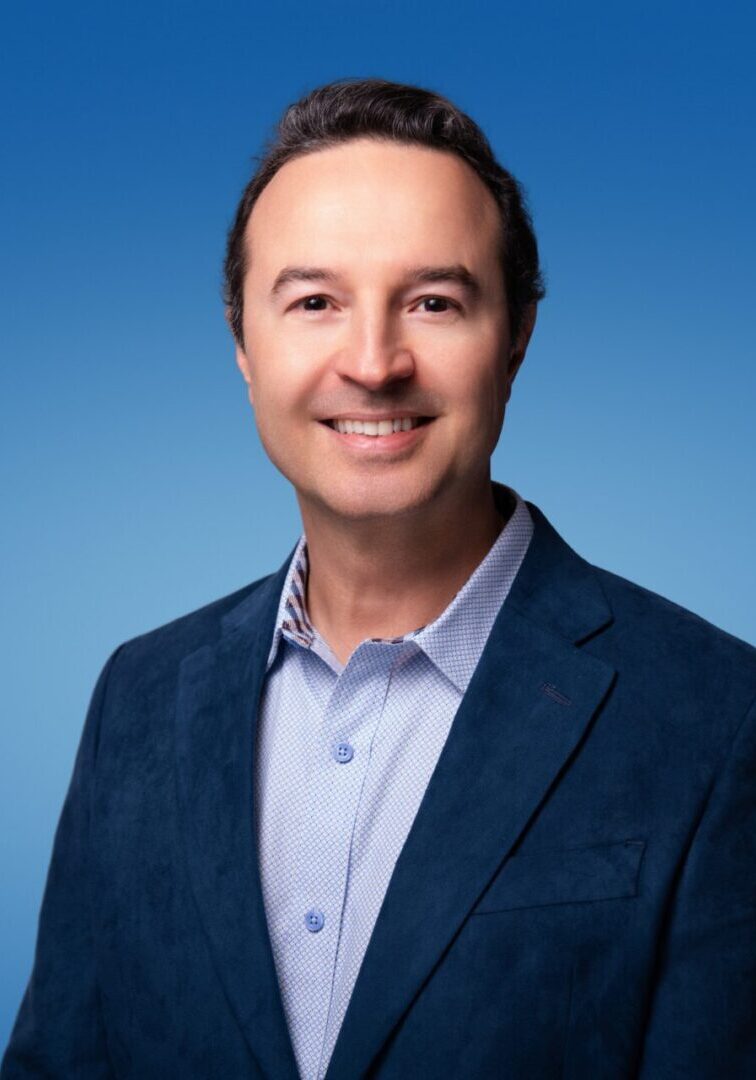 Smiling man in blue blazer on blue background